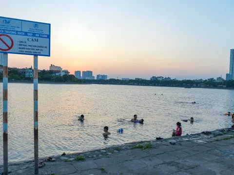 Giữa trời nắng chang chang, bất chấp biển cấm, người dân đội nón bơi ra giữa hồ Linh Đàm