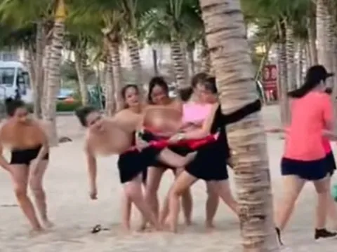 Nhóm phụ nữ để ngực trần chơi team building ở bãi biển Hạ Long
