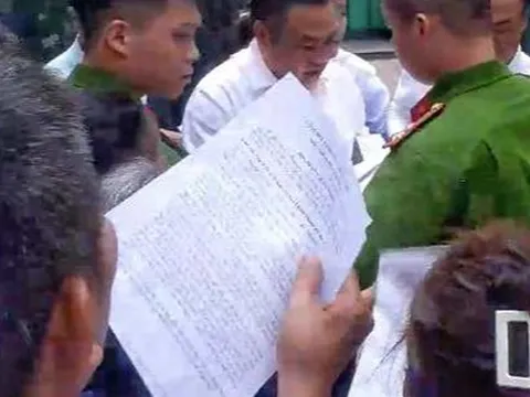 Chủ tịch Hà Nội Trần Sỹ Thanh cúi người nhặt tờ đơn của người dân bị rơi
