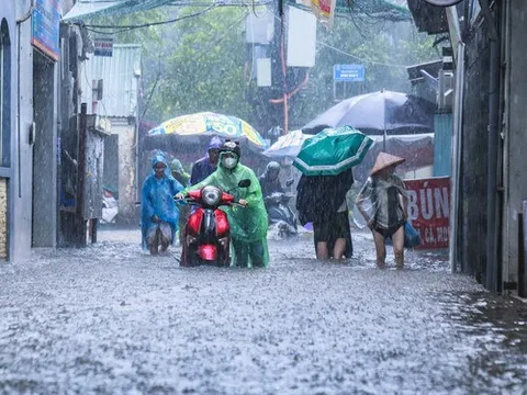 Đường phố Hà Nội biến thành “sông”, người dân bì bõm lội nước