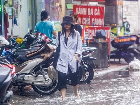 Người dân bì bõm về nhà trên những con phố ngập nước ở Hà Nội