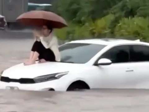Đường Hà Nội có nơi ngập gần 1m trong sáng nay, người dân ngồi lên nóc xe chờ nước rút