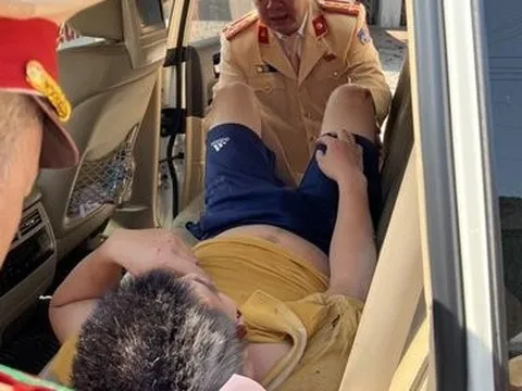 Trưởng phòng CSGT đưa nạn nhân TNGT lên xe chuyên dụng đi cấp cứu